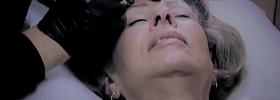 Gloria Brennan applying permanent eyeliner to a client